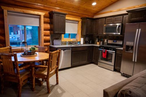 a kitchen with wooden cabinets and a table with chairs at North Haven Campground in Bonners Ferry