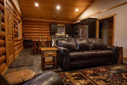 a living room with a leather couch and a kitchen at North Haven Campground in Bonners Ferry
