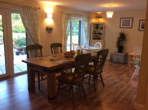 a dining room with a wooden table and chairs at The Old Grain Store Bed & Breakfast in Pidley