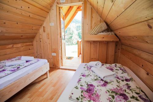 a bedroom with two beds in a wooden cabin at Apartmaji Pri Kozmavo - Little House in Bohinj