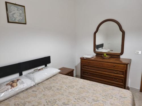 ein Schlafzimmer mit einem Bett mit einer Kommode und einem Spiegel in der Unterkunft Casa Relax Cupello in Cupello