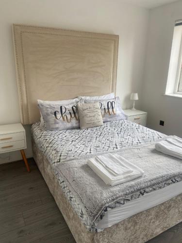 a bedroom with a bed with pillows on it at Grays Serviced Apartment in Stifford