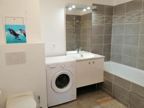 une salle de bain avec une machine à laver et un lavabo dans l'établissement Paradise - Disneyland Paris, à Chessy