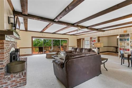 a living room with a couch and a brick fireplace at White River Mountain Manor- Million dollar view in Eureka Springs