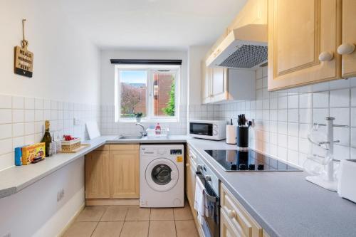 a kitchen with a washing machine and a sink at Harry Potter, Warner Brothers Apartment - Watford Junction - Watford FC - Free Parking in Watford