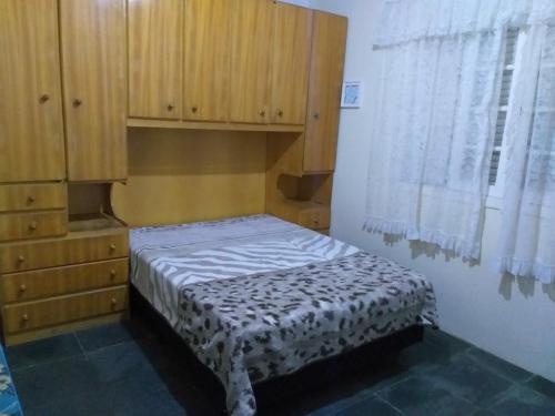 a small bed in a room with a wooden cabinet at Chacara Vale dos Sonhos Itu in Itu