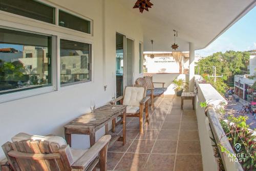 un porche con sillas y una mesa en el balcón en PH with Private Rooftop on 5th by Mamitas Beach, en Playa del Carmen