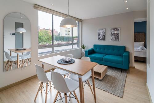 a living room with a table and a blue couch at Anima 64 in Bogotá