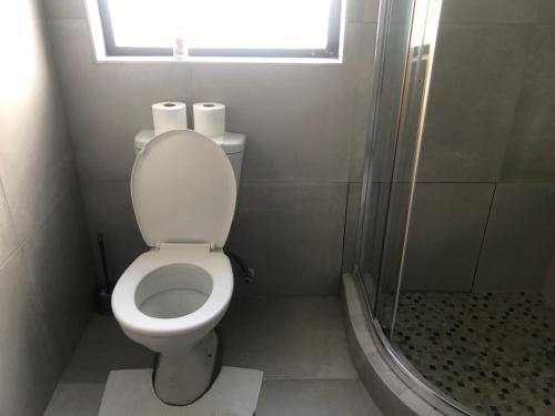 łazienka z toaletą, oknem i prysznicem w obiekcie Emabheni Self Catering w mieście Langstrand
