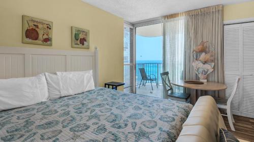 a bedroom with a bed and a table with a view at Long Beach Tower 1 800E in Panama City Beach