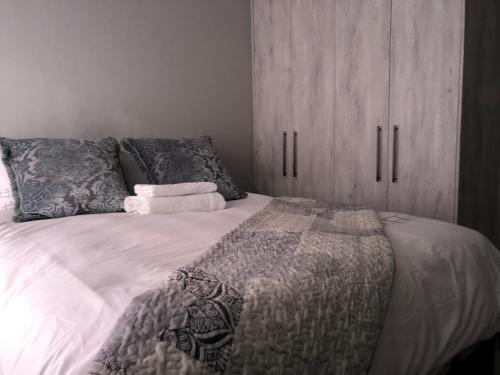 a bedroom with a bed with a wooden cabinet at Emabheni Self Catering in Langstrand