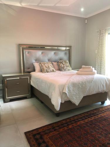 1 dormitorio con 1 cama grande con sábanas y almohadas rosas en Emabheni Self Catering, en Langstrand