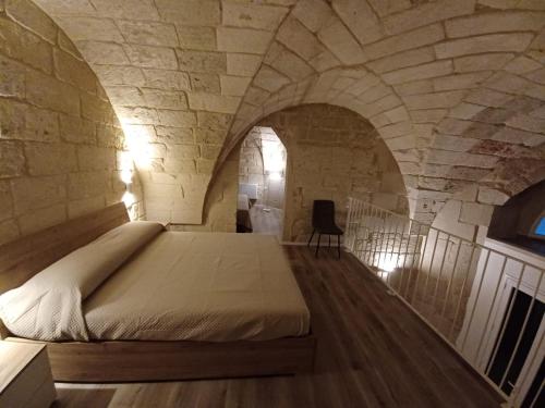 a bedroom with a bed in a stone wall at Tenuta Pigliano Dependance in Bagnolo del Salento