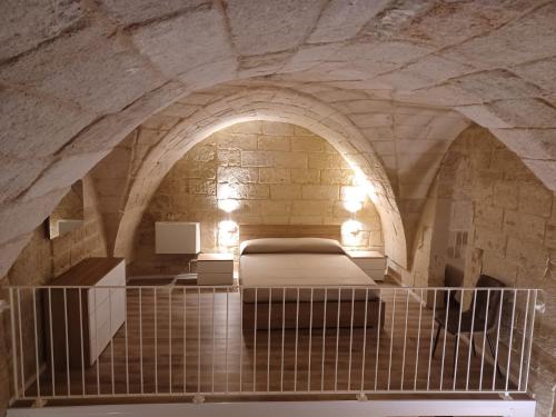 a bedroom with a bed in a stone room at Tenuta Pigliano Dependance in Bagnolo del Salento