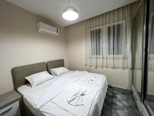 - un lit blanc dans une chambre avec fenêtre dans l'établissement Basement Floor, Merkezi, Erasta Mall karşısı '21', à Antalya
