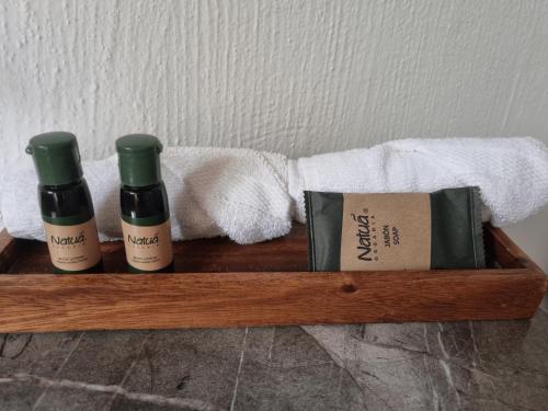 a wooden shelf with two bottles of wine and towels at Hotel La Ribereña in Ajijic