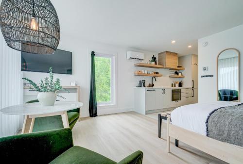 a bedroom with a bed and a table and a couch at Les Lofts du Lac des Sables by KASANIA in Sainte-Agathe-des-Monts