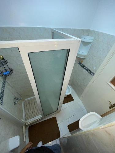 a bathroom with a shower and a toilet and a sink at Centre ville appartement in Al Hoceïma