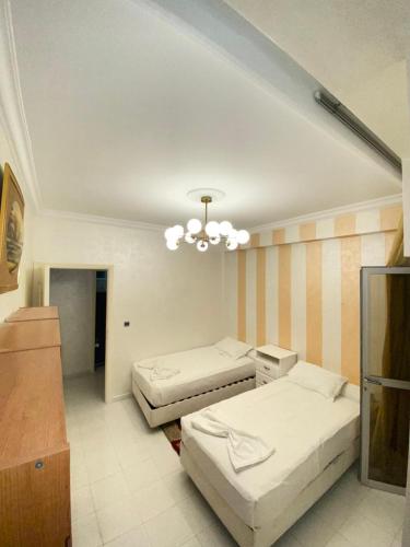 a bedroom with two beds and a chandelier at Centre ville appartement in Al Hoceïma