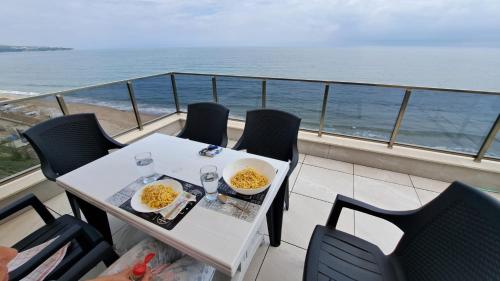a table and chairs on a balcony with the ocean at Diamond Beach Luxus Apart Obzor 28 in Obzor