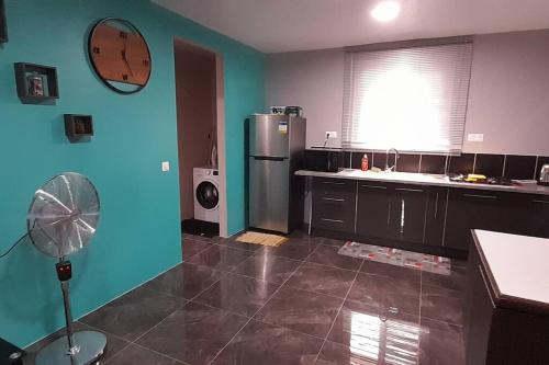 a kitchen with a refrigerator and a fan in it at Bora Temahana in Bora Bora