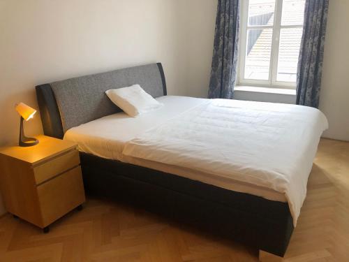 um quarto com uma cama com uma mesa de cabeceira e uma janela em Old Town City Apartment em Praga