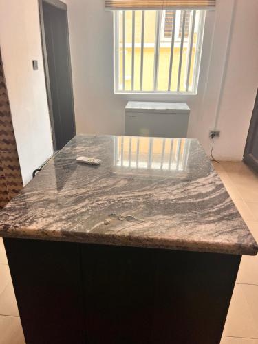 a granite counter top in a kitchen with a window at Treasure Park and Garden. Golf Estate. Simawa in Likosi