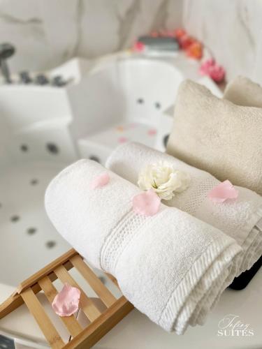 two towels on a wooden tray with flowers on them at Blooming Suites in Calais