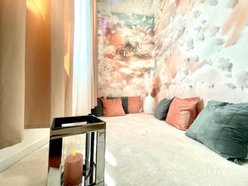 a room with a couch and a wall with clouds at Blooming Suites in Calais