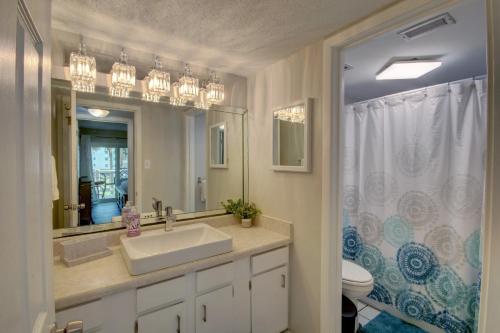uma casa de banho com um lavatório, um WC e um espelho. em 125 El Matador em Fort Walton Beach