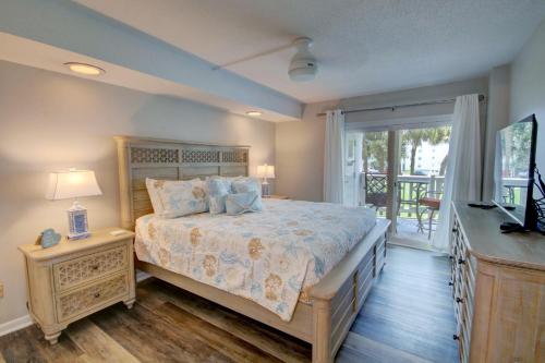 1 dormitorio con 1 cama grande y balcón en 125 El Matador, en Fort Walton Beach