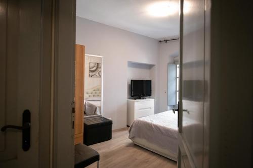 a small bedroom with a bed and a television at Alessi Appartamenti in Desenzano del Garda