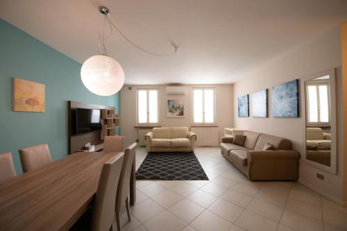 uma sala de estar com uma mesa de jantar e uma sala de estar com um sofá em Alessi Appartamenti em Desenzano del Garda
