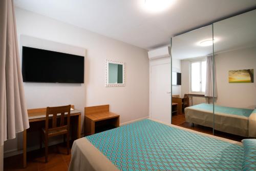 a hotel room with a bed and a desk and a desk at Alessi Appartamenti in Desenzano del Garda