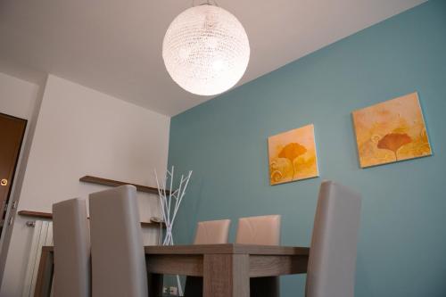 a dining room with a table and a chandelier at Alessi Appartamenti in Desenzano del Garda