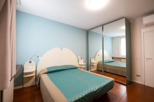 a bedroom with two beds and a mirror at Alessi Appartamenti in Desenzano del Garda