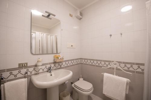 a bathroom with a sink and a toilet and a mirror at Alessi Appartamenti in Desenzano del Garda