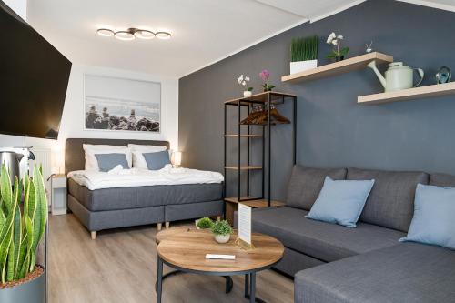 uma sala de estar com uma cama e um sofá em Federnest - Luxus-Studio - Kingsize Boxspringbett - Home-Office mit Monitor und Drucker - 11 Min Hbf em Duisburg