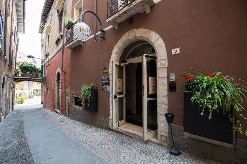 un accès à un bâtiment avec des plantes dans la porte dans l'établissement Alessi Hotel Trattoria, à Desenzano del Garda