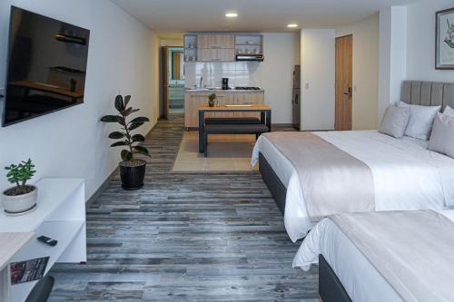 ein Hotelzimmer mit 2 Betten und einer Küche in der Unterkunft 86 suites in Bogotá