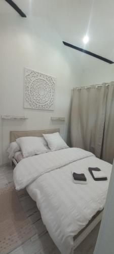 - une chambre avec un grand lit blanc et 2 chaussons dans l'établissement au p'tit logis montlouisien, à Montlouis-sur-Loire