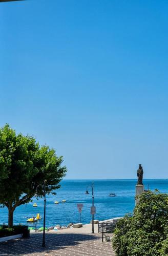 Una vista del océano con una estatua en la playa. en Uno sguardo sul mare, en Maiori