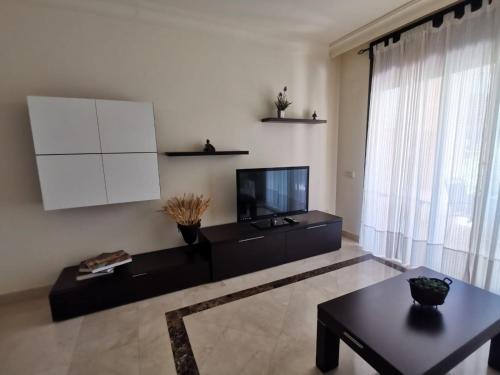 een woonkamer met een flatscreen-tv en een tafel bij Belrodagolf in San Javier
