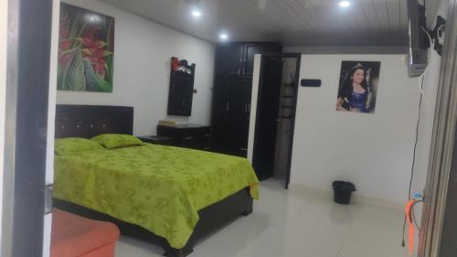 um quarto com uma cama com um edredão verde em CASA TORO em Puerto Triunfo