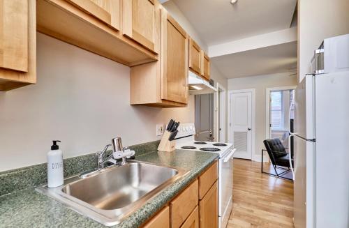 a kitchen with a sink and a stove at White House at Grand Central in Tower Grove