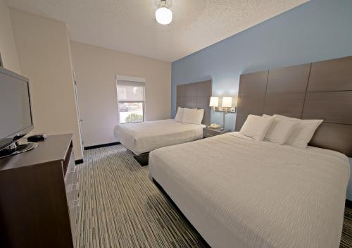 um quarto de hotel com duas camas e uma televisão de ecrã plano em All Season Suites em Pigeon Forge