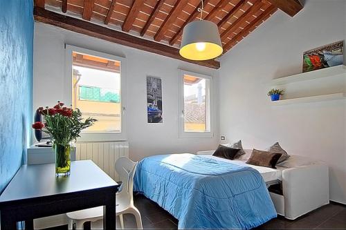 フィレンツェにあるApartments Florence San Galloのベッドルーム1室(ベッド1台、テーブル、窓付)