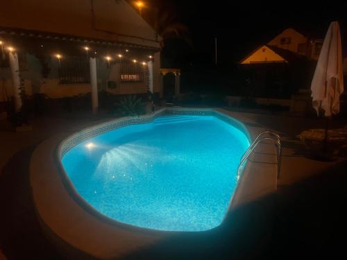 a large blue swimming pool at night with lights at Casa El Cornijal - Piscina Privada in San Javier