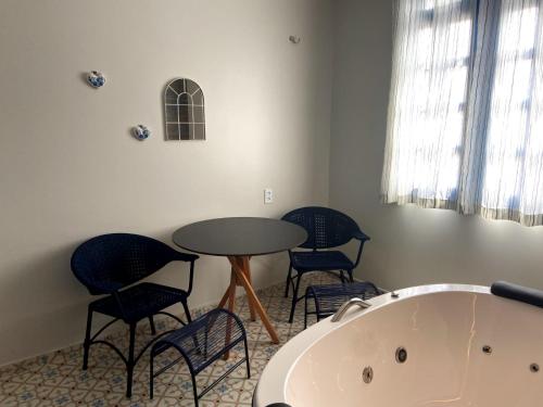 a room with a table and chairs and a bath tub at Pousada Vila de Charme in Barreirinhas