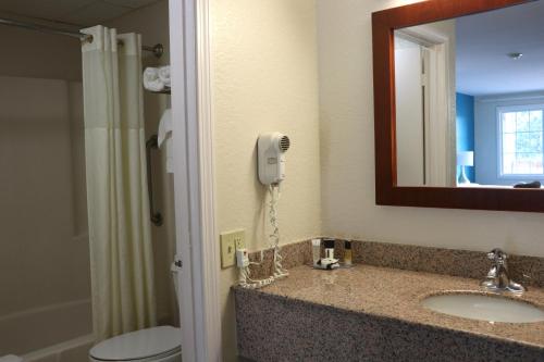 a bathroom with a sink and a phone on the wall at Sunbird Cape Cod Resort in West Yarmouth